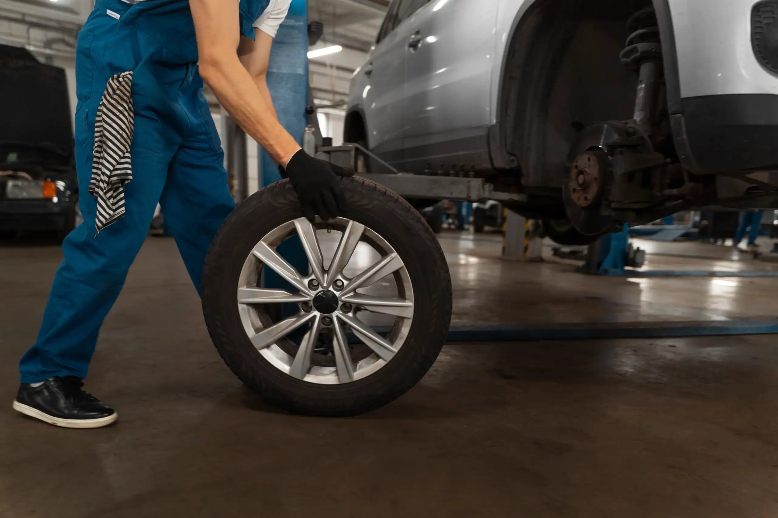 Mechanic fitting Mazda spare wheel on car in garage